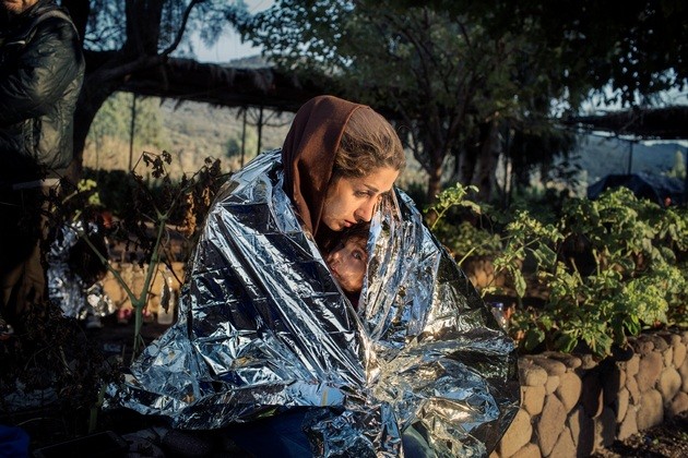 Lesvos, Greece Oct. 18, 2015. A mother and child wrapped in an emergency blanket after disembarking on the beach of Kayia, on the north of the Greek island of Lesvos.