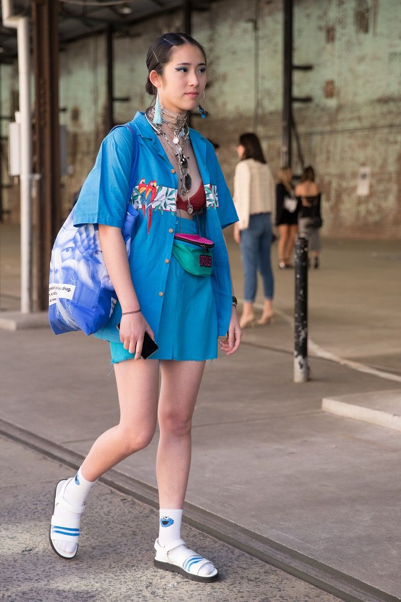 SYDNEY, AUSTRALIA - MAY 17: A fashion blogger wearing a blue rosella button up shirt, undone with blue skirt and socks with sandles during Mercedes-Benz Fashion Week Resort 18 Collections at Carriageworks on May 17, 2017 in Sydney, Australia. (Photo by Cole Bennetts/Getty Images)